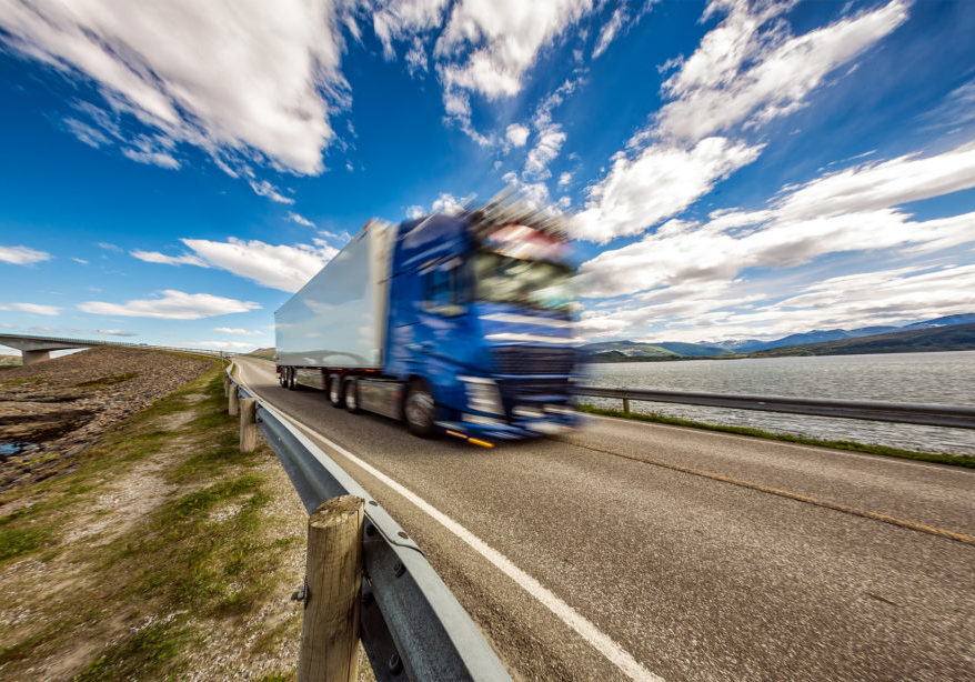 Truck rushes down the highway in the background Atlantic Ocean Road Norway. Truck Car in motion blur.